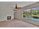 Living room offers a fireplace, ceiling fan, and view of the pool and backyard through windows at 27440 Cedar Park Ct, Wesley Chapel, FL 33544