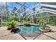 Stunning screened-in pool area featuring a spa, lush greenery, and a serene backyard setting at 27440 Cedar Park Ct, Wesley Chapel, FL 33544
