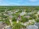 Aerial view of the home in a lush neighborhood with a pond nearby at 3000 Naughton Way, Tarpon Springs, FL 34688