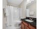 Bathroom features a shower with curtain, neutral walls, tile floor, and vanity at 3000 Naughton Way, Tarpon Springs, FL 34688