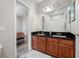 Bathroom with double sinks, dark countertops, and view to bedroom at 3000 Naughton Way, Tarpon Springs, FL 34688