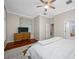 This bedroom features hardwood floors, a ceiling fan, and an ensuite bathroom at 3000 Naughton Way, Tarpon Springs, FL 34688