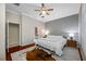 A cozy bedroom with hardwood floors, ceiling fan, and a view into the bathroom at 3000 Naughton Way, Tarpon Springs, FL 34688