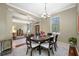 A formal dining room with a chandelier and a large window allowing for natural light at 3000 Naughton Way, Tarpon Springs, FL 34688