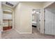 Hallway with carpet flooring that leads to a bedroom and an open stairwell at 3000 Naughton Way, Tarpon Springs, FL 34688