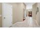 Hallway with light-colored tile flooring and white doors at 3000 Naughton Way, Tarpon Springs, FL 34688