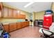 Spacious laundry room with washer, dryer, cabinets, countertops, and rolling chair at 3000 Naughton Way, Tarpon Springs, FL 34688