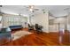 Spacious living room featuring wood floors, ceiling fans, and ample natural light at 3000 Naughton Way, Tarpon Springs, FL 34688