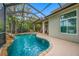 Relax in this screened pool with a unique rock waterfall feature and beautiful lush landscaping at 3000 Naughton Way, Tarpon Springs, FL 34688