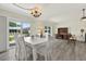 Open dining room featuring a table, six chairs, a chandelier and access to the lanai at 3146 37Th S Ln # A, St Petersburg, FL 33711