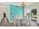 Cozy dining area with white furniture, bright accent wall, and sliding doors leading to outdoor space at 3146 37Th S Ln # A, St Petersburg, FL 33711