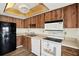 Traditional kitchen with wood cabinets, white appliances, and a unique lit ceiling feature at 3146 37Th S Ln # A, St Petersburg, FL 33711