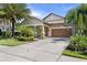 Charming single-story home with a well-manicured lawn, mature landscaping, and a two-car garage at 32193 Watoga Loop, Wesley Chapel, FL 33543