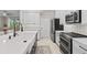 A modern kitchen with an island, white cabinets, stainless steel appliances, and herringbone tile backsplash at 32193 Watoga Loop, Wesley Chapel, FL 33543