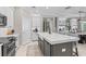 Modern kitchen with an island, barstool seating, stainless steel appliances, and an adjoining dining area at 32193 Watoga Loop, Wesley Chapel, FL 33543