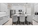 Modern kitchen featuring white cabinets, stainless steel appliances, and a center island with bar seating at 32193 Watoga Loop, Wesley Chapel, FL 33543