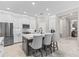 Modern kitchen with stainless steel appliances, white cabinets, kitchen island with counter seating, and granite countertops at 32193 Watoga Loop, Wesley Chapel, FL 33543