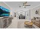 Open concept living room connecting to the dining room, featuring a large smart TV and comfortable leather couches at 32193 Watoga Loop, Wesley Chapel, FL 33543