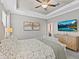 This main bedroom has gray walls, a ceiling fan, and a television on the wall at 32193 Watoga Loop, Wesley Chapel, FL 33543