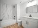 Bright bathroom boasts a shower-tub, and white vanity with a black framed mirror at 3908 Douglas Hill Pl, Parrish, FL 34219