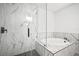 Bright bathroom featuring marble tile shower, stand alone tub with modern matte black plumbing fixtures at 3908 Douglas Hill Pl, Parrish, FL 34219