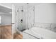 Bright bathroom featuring marble tile shower, stand alone tub with modern matte black plumbing fixtures at 3908 Douglas Hill Pl, Parrish, FL 34219