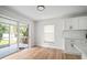 Bright dining area with white cabinets, light wood flooring, and a view of the backyard at 3908 Douglas Hill Pl, Parrish, FL 34219
