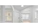 Bright, neutral-toned foyer with high ceilings, modern lighting, and sleek doors leading to the home's interior at 3908 Douglas Hill Pl, Parrish, FL 34219