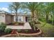 Charming exterior view showcasing a well-manicured lawn, lush palm trees, and a welcoming front entrance at 3908 Douglas Hill Pl, Parrish, FL 34219