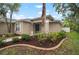 Exterior of home featuring a well-manicured lawn, beautiful trees, and a welcoming entrance at 3908 Douglas Hill Pl, Parrish, FL 34219