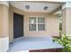 Inviting porch featuring a dark-colored front door, neutral-toned siding, and natural lighting from a nearby window at 3908 Douglas Hill Pl, Parrish, FL 34219