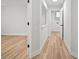 Hallway leading to laundry room with wood flooring and white walls at 3908 Douglas Hill Pl, Parrish, FL 34219