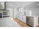 Modern kitchen with white cabinets, stainless steel appliances, quartz countertops, and hardwood floors at 3908 Douglas Hill Pl, Parrish, FL 34219