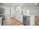 Bright kitchen with modern appliances, light wood floors, and an island with quartz countertops at 3908 Douglas Hill Pl, Parrish, FL 34219