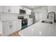 Modern kitchen with stainless steel appliances, quartz countertops, subway tile backsplash, and hardwood floors at 3908 Douglas Hill Pl, Parrish, FL 34219