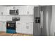 Well-lit kitchen with white cabinets, stainless steel refrigerator, and quartz countertop at 3908 Douglas Hill Pl, Parrish, FL 34219