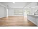 Bright, open living room featuring hardwood floors, white walls, and natural light through windows and sliding glass door at 3908 Douglas Hill Pl, Parrish, FL 34219