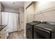 Bright bathroom featuring a walk-in shower, neutral paint, tile floors, and a washer and dryer at 4345 Bayside Village Dr # 303, Tampa, FL 33615