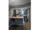 Charming galley kitchen featuring gray cabinets, bar seating, and pass-through window at 4705 Ne 1St Ne St # 327, St Petersburg, FL 33703