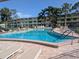 Beautiful community pool surrounded by lounge chairs, lush landscaping, and a secure fence at 4705 Ne 1St Ne St # 327, St Petersburg, FL 33703