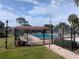 Community pool area featuring a secure fence, lush greenery, and inviting lounge spaces at 4705 Ne 1St Ne St # 327, St Petersburg, FL 33703