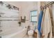 Bright bathroom featuring a soaking tub, tiled walls, and beach-themed decor creating a tranquil atmosphere at 5112 Parkway Blvd, Land O Lakes, FL 34639