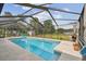 An inviting swimming pool in a screened enclosure, complemented by lush greenery at 5112 Parkway Blvd, Land O Lakes, FL 34639