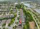 Aerial view of a residential neighborhood featuring modern homes, green spaces, and a nearby lake at 6016 Shadowlake Dr, Apollo Beach, FL 33572