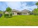 Expansive backyard with lush green lawn, mature landscaping, and outdoor living area at 6016 Shadowlake Dr, Apollo Beach, FL 33572