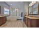 Bathroom featuring double vanity, soaking tub and glass-enclosed shower at 6016 Shadowlake Dr, Apollo Beach, FL 33572