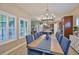 Well-lit dining room features a large window, chandelier, and view into the home's kitchen at 6016 Shadowlake Dr, Apollo Beach, FL 33572