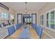 An elegant dining room featuring a long wooden table with blue striped chairs and blue decorations at 6016 Shadowlake Dr, Apollo Beach, FL 33572
