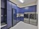 Spacious laundry room with blue cabinets, stainless steel appliances and white floors at 6016 Shadowlake Dr, Apollo Beach, FL 33572