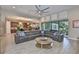 Open concept living room features a large sectional sofa, decorative art pieces, and a view of the kitchen at 6016 Shadowlake Dr, Apollo Beach, FL 33572